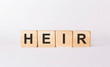 Word HEIR made from wooden blocks on white background