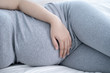 © Windawake - Pregnant woman sleeping in bed at home. Close up of pregnant woman lying in bed and touching her belly.