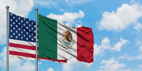Wall Mural - United States and Mexico flag waving in the wind against white cloudy blue sky together. Diplomacy concept, international relations.
