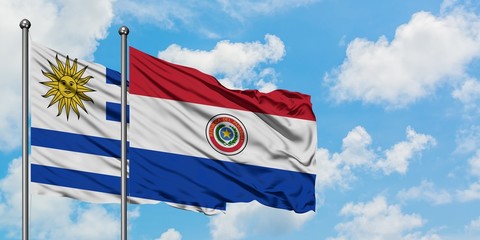 Uruguay and Paraguay flag waving in the wind against white cloudy blue sky together. Diplomacy concept, international relations.