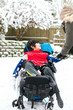 © Jaren Wicklund - Disabled boy in wheelchair playing with snow in winter