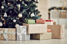 Close-up Of Christmas Presents In Wrapping Paper Are On The Floor Under The Christmas Tree