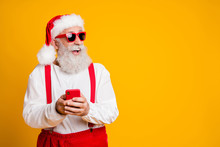 Profile Side Photo Of Crazy Funky Grey Hair Hipster Grandfather In Santa Claus Hat Use Cellphone Find Tradition X-mas Eve Shopping Discounts Look Copyspace Isolated Bright Color Background