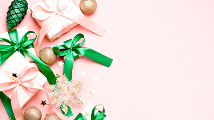 pink christmas card or new year background, flat lay, copy space. pastel pink gift boxes and green, 