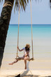 © allenkayaa - A woman in a hat on a swing on the shore of the turquoise sea