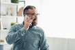 © LIGHTFIELD STUDIOS - handsome businessman in shirt talking on smartphone and looking away