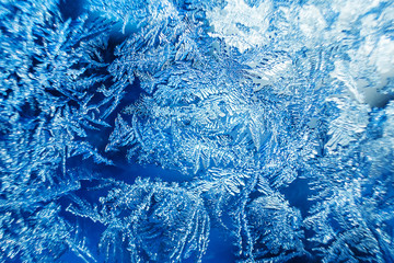 Beautiful frozen patterns on glass, macro photo. The concept of winter, the beauty of nature, frost, cold. Abstract background image.