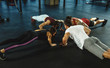 © master1305 - A group of muscular athletes doing workout at the gym. Gymnastics, training, fitness workout flexibility. Active and healthy lifestyle, youth, bodybuilding. Training in stretching and plank.