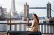 Elegante Touristin in London genießt die Aussicht auf die Tower Brücke und Skyline während eines Städtetrips