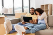 © Syda Productions - mortgage, people and real estate concept - happy african american couple with tablet pc computer sitting on sofa at new home