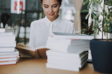 Wall Mural - Smiling woman with piles of books stock photo