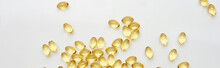 Top View Of Golden Fish Oil Capsules Scattered On White Background, Panoramic Shot