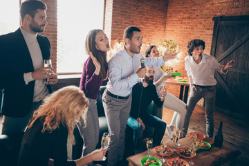 Wall Mural - Photo of best friends celebrating newyear party singing karaoke songs hold microphone drink golden wine eat snacks food wear formalwear sitting sofa restaurant indoors