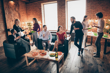 Wall Mural - Photo of positive festive birthday party people friendship chatting clinking glasses drink golden wine eating snacks wear formalwear sitting sofa loft room indoors