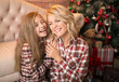 © murika - Portrait of a joyful mom and daughter against the background of the Christmas interior.