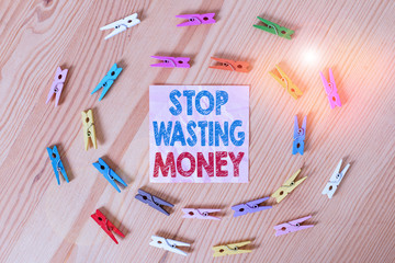 Conceptual hand writing showing Stop Wasting Money. Concept meaning Organizing Management Schedule lets do it Start Now Colored crumpled papers wooden floor background clothespin