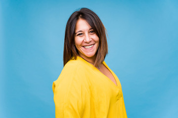 Middle aged woman smiling a against blue background