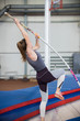 Pole vaulting indoors - young sportive woman with ponytail leaning on the pole and about to jump