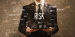 Risk with businessman holding a tablet computer on a dark vintage background