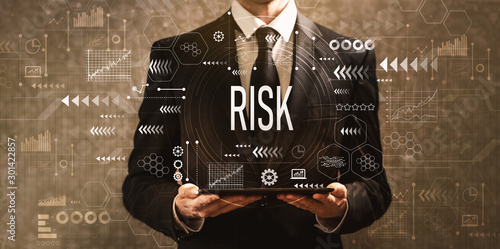 Cuadros en Lienzo Risk with businessman holding a tablet computer on a dark vintage background