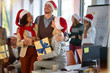 © luckybusiness - Christmas party in office. friends in santa hat celebrating Christmas in office
