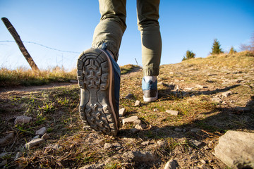 Wall Mural - woman hiker walking through the mountains with professional boots