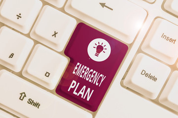 Conceptual hand writing showing Emergency Plan. Concept meaning procedures for handling sudden or unexpected situations White pc keyboard with note paper above the white background