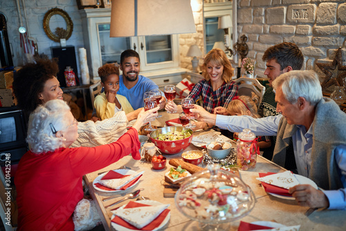 Fotografía Family having Christmas dinner at home with happy friends