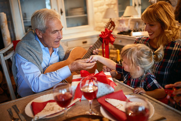 Wall Mural - grandfather celebration Christmas time with his little granddaughter