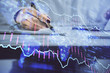© peshkova - Double exposure of woman's hands making notes with forex graph hologram. Concept technical analysis.