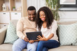 © Syda Productions - technology, internet and people concept - happy african american couple with tablet computer at home
