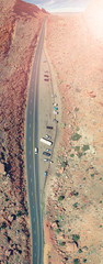 Canvas Print - Drone view of orange mountain landscape covered with sparse vegetation and curved road creating beautiful scenario of a National Park