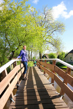 Woman Walking On Bridge In Cosy Small Dutch Village Giethoorn, Netherlands