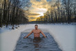 Winter swimming in cold water. Ice hole in the forest, extreme hardening of the body