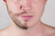 the lower half of the man s face is only half shaved. close up