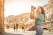 © Davide Marconcini - Girl tourist on vacation in Verona taking pictures, Italy, in front of the arena before the opera