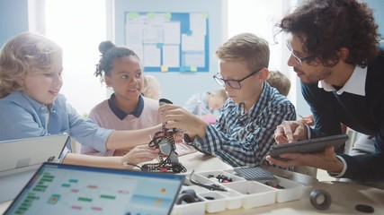 Wall Mural - elementary school robotics classroom: diverse group of brilliant children with enthusiastic teacher 