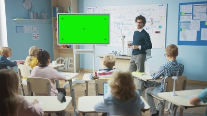 Wall Mural - in the elementary school classroom: teacher uses horizontal green mock-up screen interactive digital