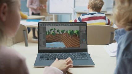 Elementary School Computer Science Classroom: Over the Shoulder View of Two Kids Using Laptop Computer to Design 3D Game, Building Level in Strategic Roleplaying Videogame