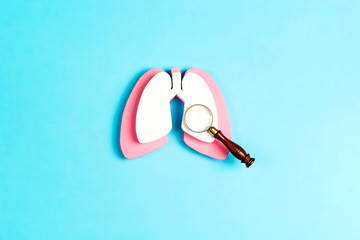 Wall Mural - Prevention of pulmonary disease. Lung symbol with magnifier on a blue background.