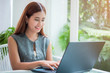 © totojang1977 - Happy asian business woman working with laptop computer at coffee shop in the morning