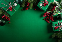 Christmas Background Concept. Top View Of Christmas Green Gift Box With Decoration, Spruce Branches And Red Berries On Green  Background.