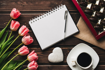 Wall Mural - bouquet of pink Tulip flowers and a Cup of coffee with a box of sweet chocolates on the wooden table