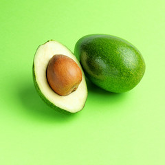 Wall Mural - Ripe sliced avocado on a green background