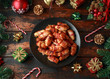 © grinchh - Christmas Pigs in blankets, sausages wrapped in bacon with decoration, gifts, green tree branch on wooden rustic table