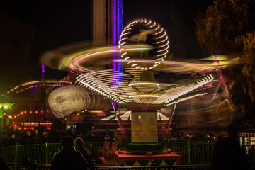 Wall Mural - A blurry colorful carousel in motion at the amusement park, night illumination. Long exposure.