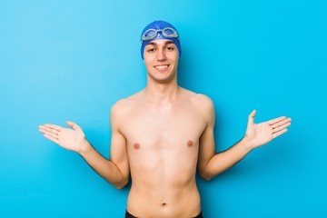 Wall Mural - Young swimmer man showing a welcome expression.