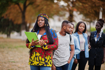 Wall Mural - Row of group five african college students spending time together on campus at university yard. Black afro friends studying. Education theme.