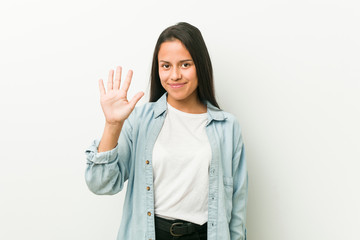 Young hispanic woman smiling cheerful showing number five with fingers.