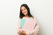© Asier - Young hispanic woman holding some notebooks happy, smiling and cheerful.